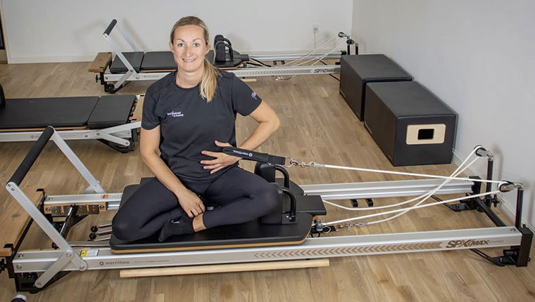 Kvinde i skrædderstilling på træningsmaskine