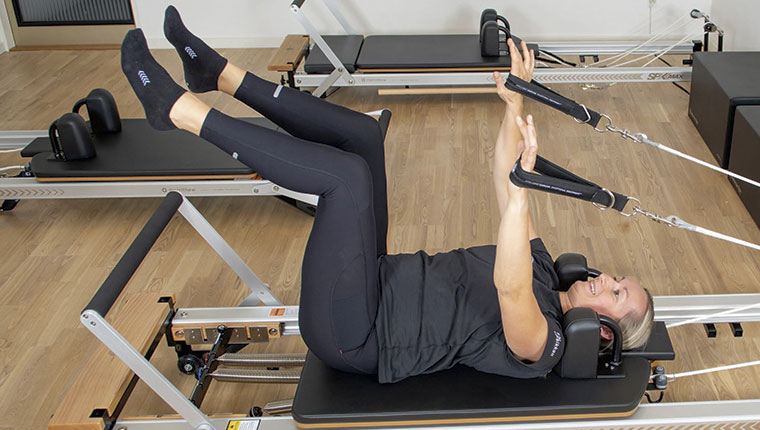 Kvinde træner rygliggende i maskine